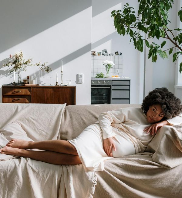 Woman meditating peacefully with hands on her pregnant belly.